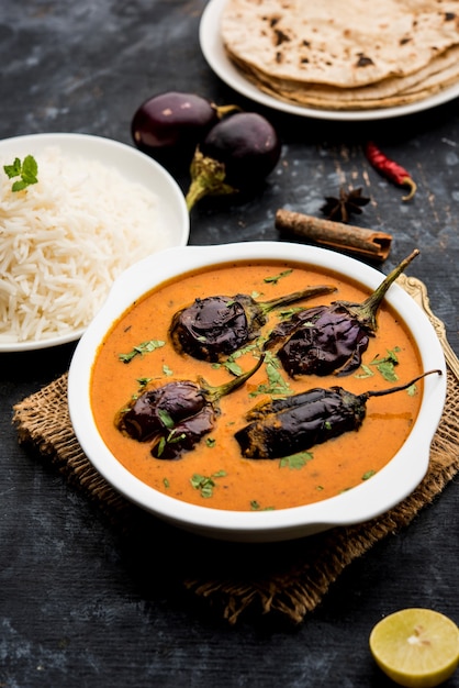 Baingan o baigan masala o berenjena o berenjena al curry servido con chapati y arroz, enfoque selectivo