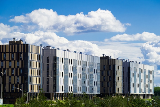 Bairro residencial com moderno edifício de seis andares no fundo de nuvens flutuantes