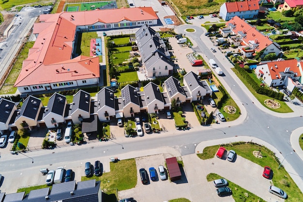 Bairro residencial moderno na cidade da Europa, vista aérea. Bairro residencial no pôr do sol, vista aérea. Ruas da cidade com casas luxuosas e carro estacionado