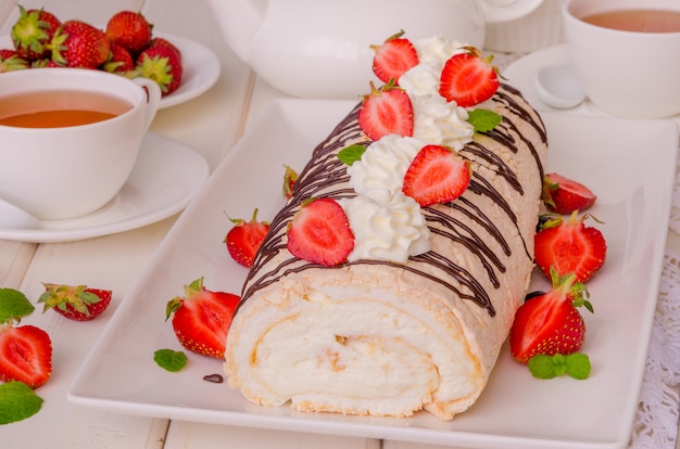 Baiserbrötchen Pavlova mit Schlagsahne, frischen Erdbeeren und Schokoladenglasur.