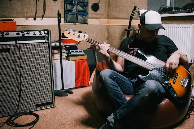 Baixista tocando violão em estúdio de música