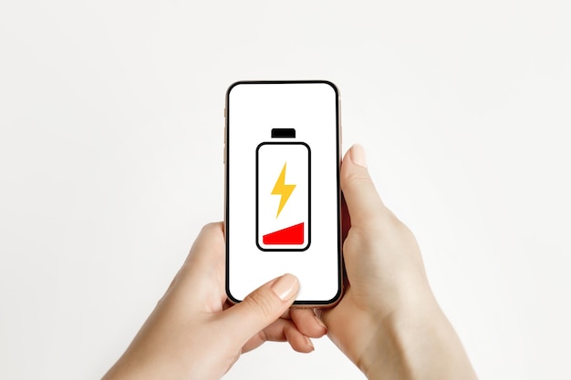 Baja carga de la batería de su teléfono móvil Mano femenina sosteniendo un teléfono inteligente de baja carga
