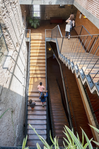 Una bajada con escaleras de madera y metal negro.