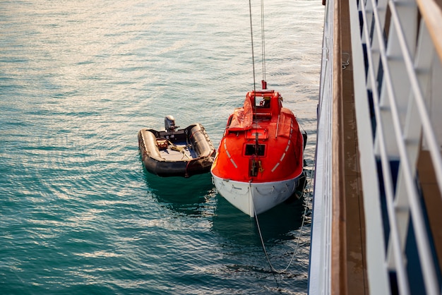 Bajando el bote salvavidas naranja al agua en las aguas del Ártico