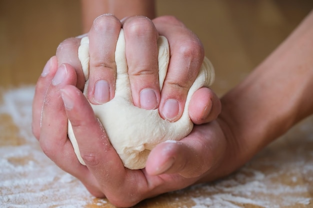 Baker amassa um pedaço de massa nas palmas das mãos