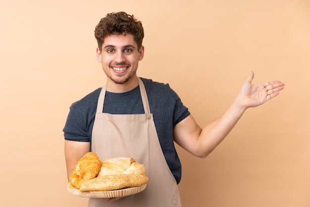 Baker macho sosteniendo una mesa con varios panes