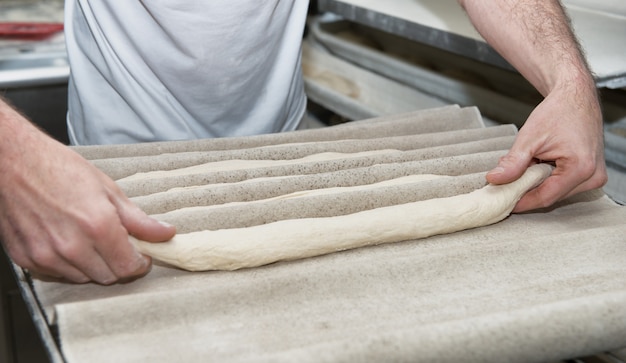 Baker prepara masa de pan, de cerca en sus manos