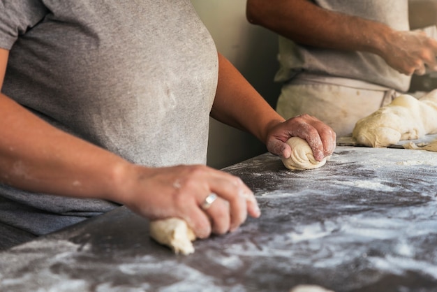 Baker preparando pan. Cerca de las manos amasando la masa. Concepto de panadería.