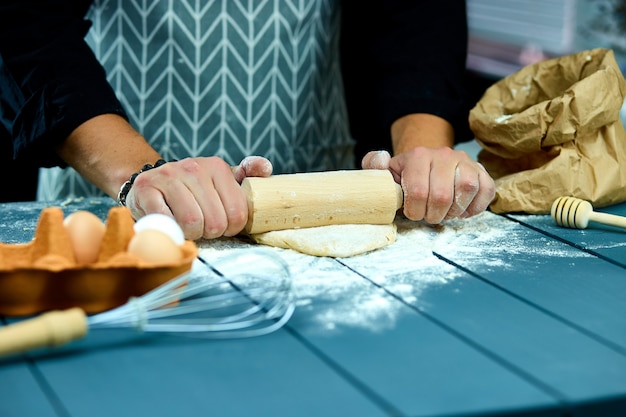 Baker, preparar massa fresca com rolo na mesa da cozinha
