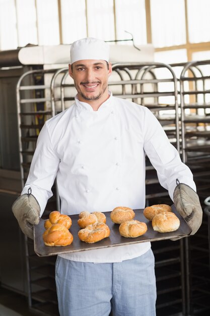 Baker que mostra a bandeja dos rolos