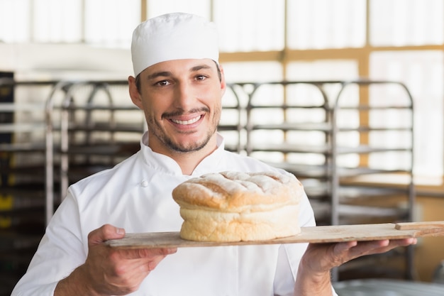 Baker que mostra um pão recém-assado