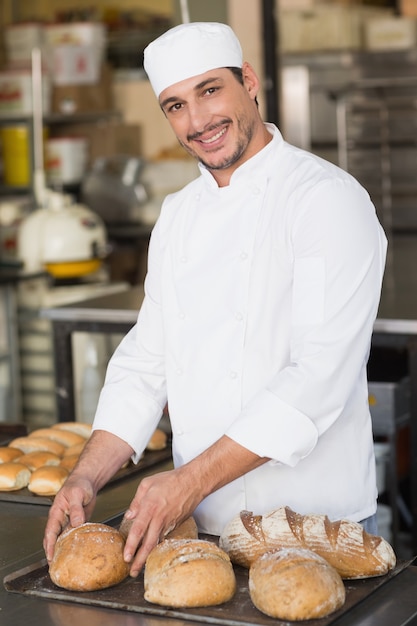 Baker que verifica o pão recém-assado