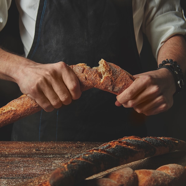 Baker quebra baguete fresca orgânica, conceito de panificação