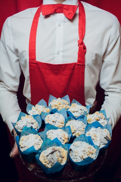 Baker, segurando uma bandeja com cupcakes