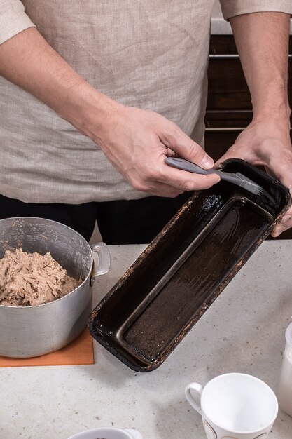 Baker unte uma assadeira de pão.