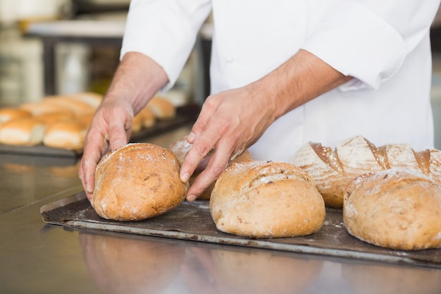 Foto baker, verificando o pão acabado de cozer