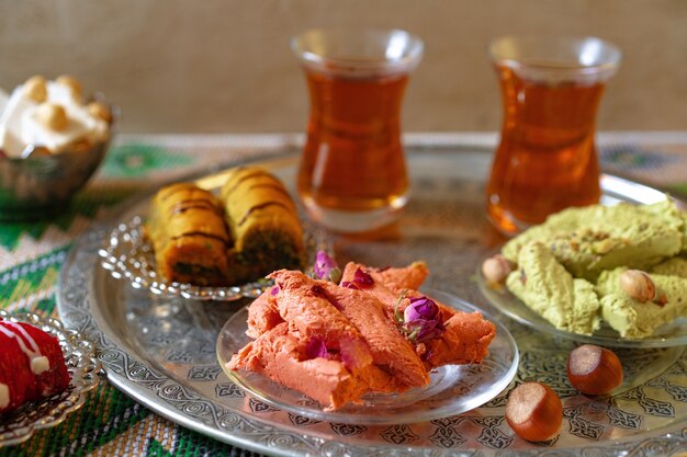 Baklava dulce turco en bandeja de metal con té turco