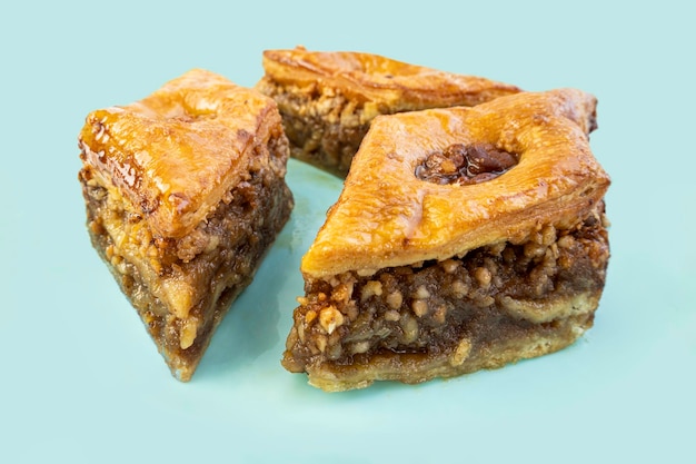 Baklava de dulzura oriental tradicional con nueces en una vista superior de placa azul