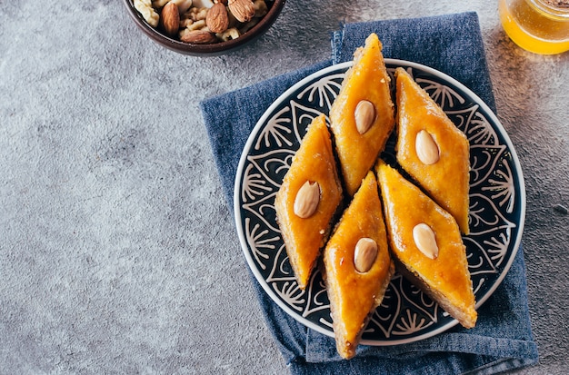 Baklava. Ramadan Dessert.Arabischer Nachtisch mit Nüssen und Honig, Tasse Tee auf einem konkreten Hintergrund.