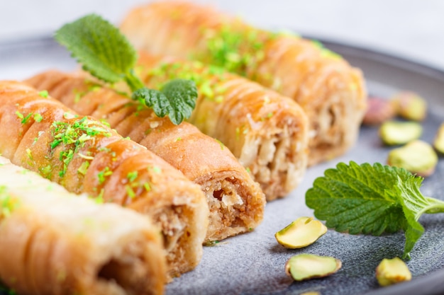 Baklava, traditionelle arabische Bonbons in der grauen keramischen Platte auf einem grauen Beton. Nahansicht.