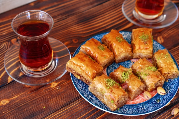 Baklava turco doce com chá turco em fundo de madeira