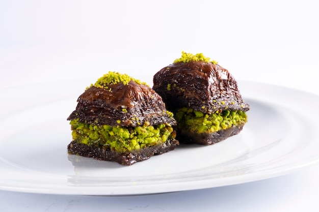 Baklavas de pistacho de chocolate de cacao griego turco en placa sólida blanca