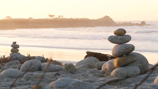 Foto balanceamento de rochas em pilhas de pirâmide de pebble beach de pedras oceano costa água do mar