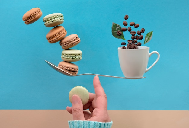 Foto balanceamento de xícara de café e macarrão em um dedo