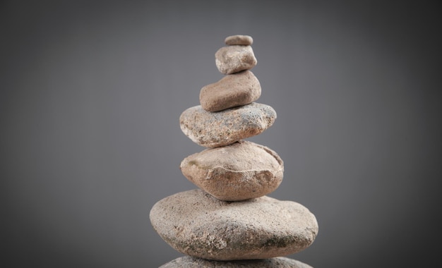 Balancieren Sie Steine auf grauem Hintergrund.