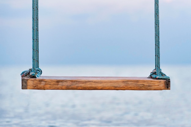 Balanço de madeira com cordas com vista para o mar Balanço na beira-mar Fechar