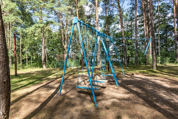 Balanço e barras horizontais no playground na floresta de pinheiros