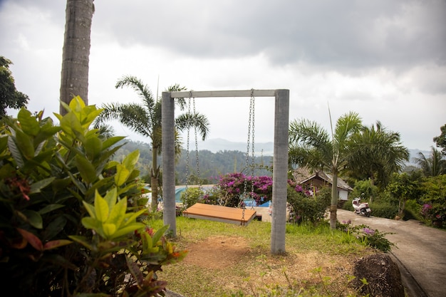 Balanço romântico vazio em um jardim paradisíaco tropical na encosta de uma montanha