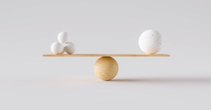 Foto balanza de madera que equilibra una bola grande y cuatro pequeñas. concepto de armonía y equilibrio.