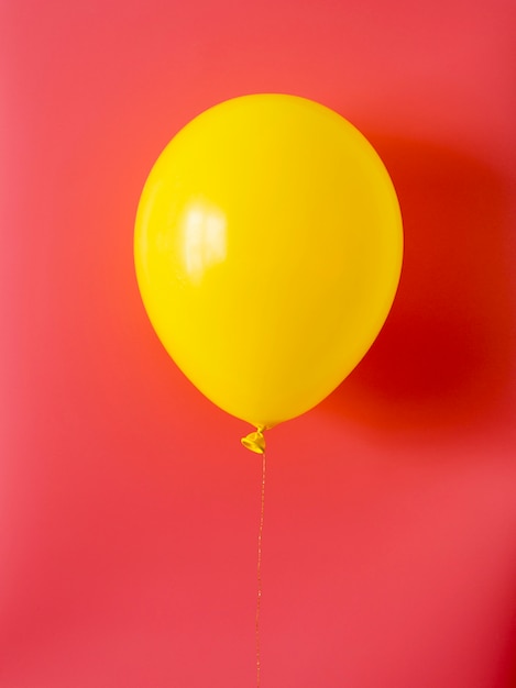 Foto balão amarelo sobre fundo vermelho