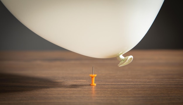 Balão branco e alfinete em cima da mesa