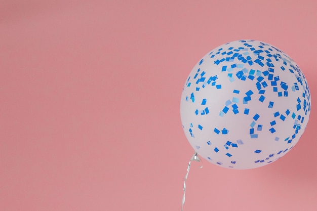 Balão branco e azul em um fundo rosa