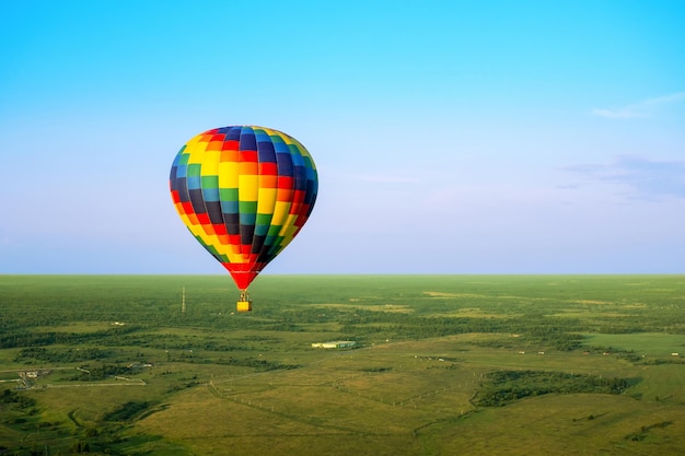 Balão de ar colorido está voando em voo livre Balão multicolorido no céu azul