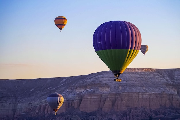 Balão de ar quente voando sobre a paisagem rochosa na Capadócia Turquia