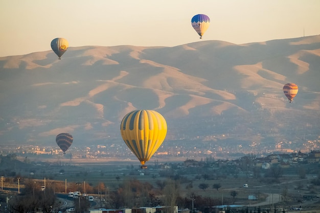 Balão de ar quente voando sobre a paisagem rochosa na Capadócia Turquia