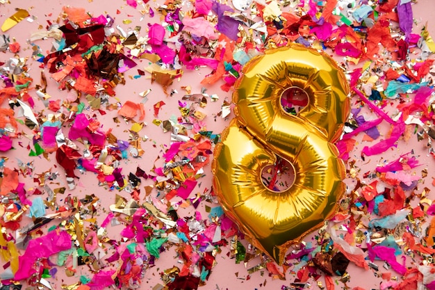 Balão de comemoração de aniversário de ouro em um fundo de brilho de confete