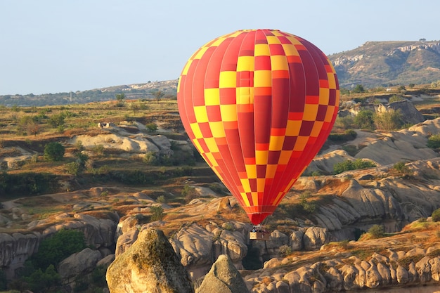 Foto balão está voando em área montanhosa na capadócia