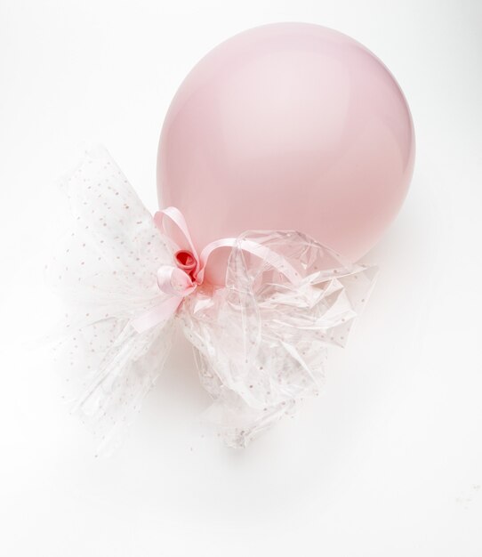 Balão rosa com delicados laços brancos. Isolado no fundo branco.