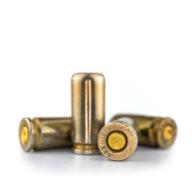 Balas de 9 mm aisladas sobre fondo blanco, vista cercana, munición para una pistola