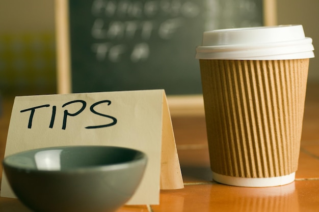 Balcão de café com xícara de café, preços e caixa de gorjetas