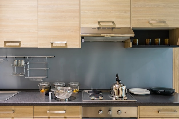 Balcão de cozinha moderno com acabamento em madeira dura e bancada em granito e armário de madeira