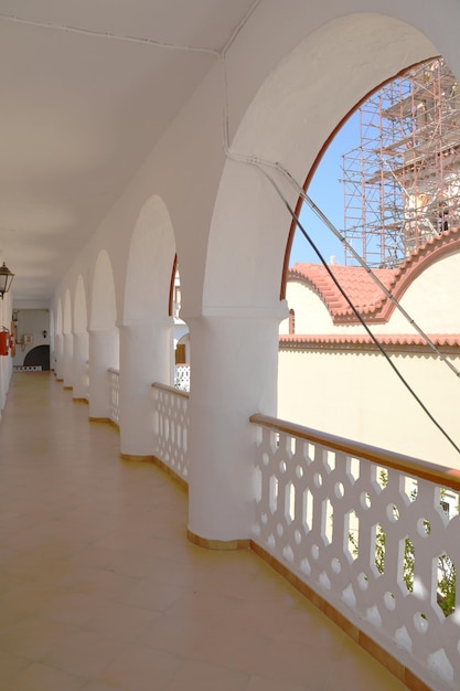 El balcón blanco con arcos y construcción de edificios en el fondo