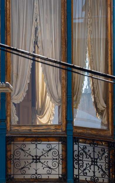 Balcón y ventana modernista de Granollers con su cortina bellamente bordada en una casa de Granollers