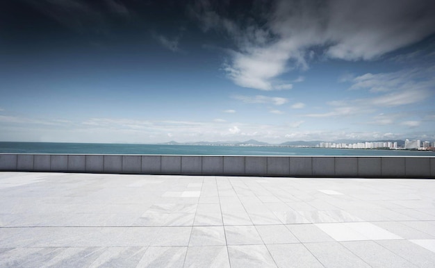 Un balcón con vista a la ciudad y al mar de fondo.