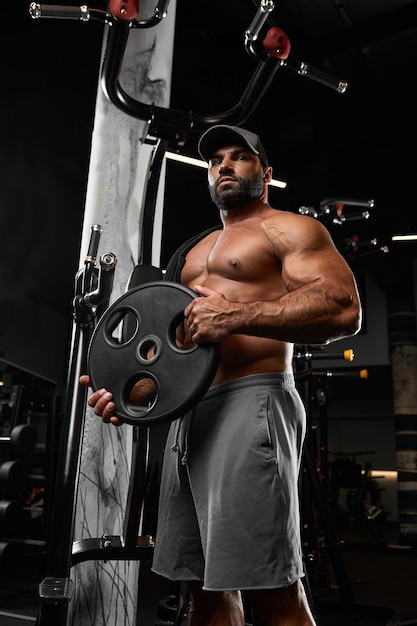 Bald brutal sexy forte fisiculturista atlético fitness homem bombando músculos abdominais treino musculação conceito fundo