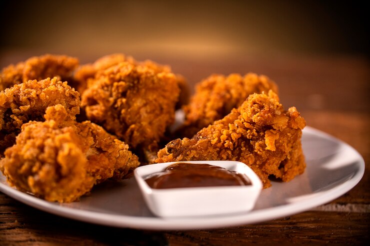 Foto balde cheio de frango frito kentucky crocante com fumaça e molho de churrasco no fundo marrom. foco seletivo.